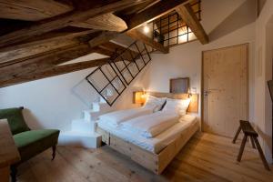 a bedroom with a large bed and a green chair at das-hornsteiner in Passau