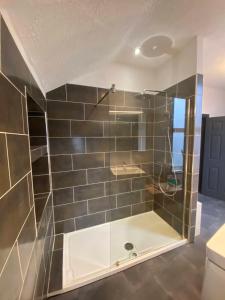 a bathroom with a shower with a glass door at Gorgeous Town Centre 3-Bed 2-Bath Apartment Parking Available in Harrogate +7 photos