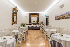 a dining room with white tables and white chairs at Hotel Accademia in Florence