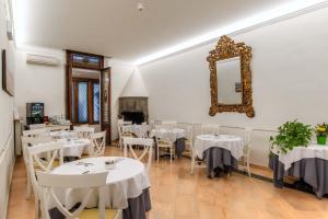 a dining room with white tables and a mirror at Hotel Accademia in Florence