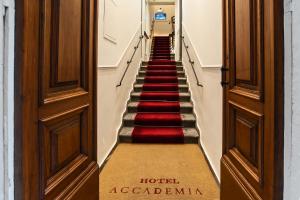 una escalera en un hotel con alfombra roja en Hotel Accademia en Florencia