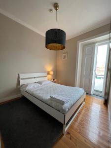 a bedroom with a bed and a large window at Suites & Apartments DP VFXira in Vila Franca de Xira