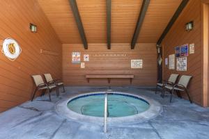a pool in a room with chairs and a bench at Sunrise 9 in Mammoth Lakes