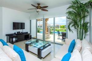 a living room with a white couch and a ceiling fan at Luxury Condos at Mareazul Beachfront Complex with Resort-Style Amenities in Playa del Carmen