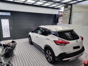 a white car parked in a garage next to a motorcycle at Lin's B&B in Pingtung City