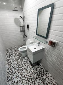 a bathroom with a toilet and a sink and a mirror at Lin's B&B in Pingtung City