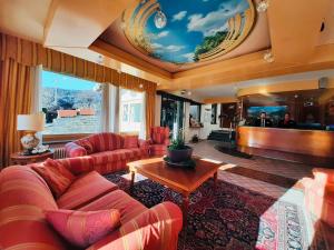 una gran sala de estar con sofás rojos y un escenario. en HG Hotel Italia en Brusson