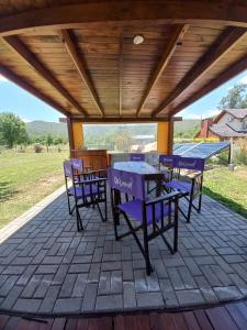 a patio with purple chairs and tables on it at R y C Nuestro Lugar in Villa General Belgrano
