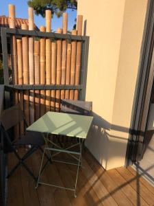 stół i krzesło na balkonie z ogrodzeniem w obiekcie Le Studio Sausset w mieście Sausset-les-Pins