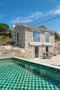 uma casa de pedra com uma piscina em frente em Casa Monte do Cervo em Vila Nova de Cerveira