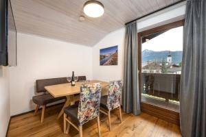 a dining room with a table and chairs and a large window at Wohn-Leben Altenmarkt Apartments in Altenmarkt im Pongau