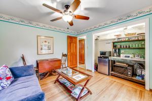 a living room with a blue couch and a ceiling fan at Hummingbird Garden Retreat in Santa Rosa