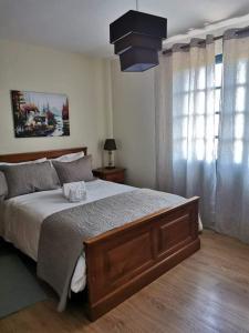 a bedroom with a large bed and a chandelier at Alojamento Local Madre de Cima in Vinhais