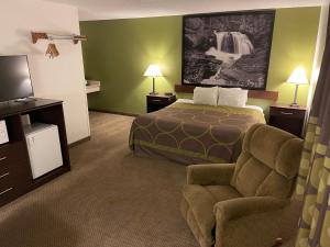 a hotel room with a bed and a chair at Studio 1 Hotel & Extended Stay - Missoula in Missoula
