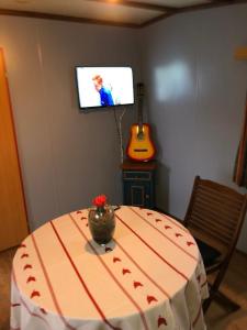 a room with a table and a tv on a wall at LE CHALET DE CANDICE TOUT CONFORT PECHE COMPRISE in Saint-Michel +11 photos