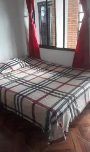 ein großes Bett in einem Zimmer mit Fenster in der Unterkunft FINCA CAMPESTRE EL MIRADOR VIOTA in Viotá