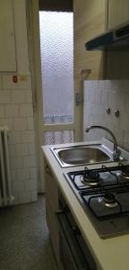 uma cozinha com um fogão e um lavatório em Casa arcobaleno em Asti