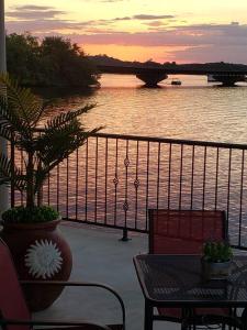 balcón con mesa, sillas y vistas al río en Beautiful Lakefront Condo 2 En Suite BRs, en Hot Springs