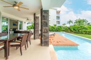 a villa with a dining room and a swimming pool at Luxury Condos at Mareazul Beachfront Complex with Resort-Style Amenities in Playa del Carmen