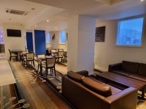 a living room with a couch and a table and chairs at Holiday Inn Express Wakefield, an IHG Hotel in Wakefield