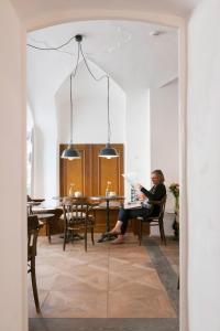 a woman sitting in a chair reading a paper in a room at das-hornsteiner in Passau +76 photos