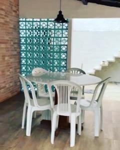 a dining room with a white table and chairs at Casa de Praia - Suítes in Arraial do Cabo