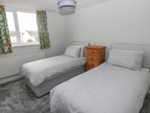 a bedroom with two beds and a window at 21 Sandfield Road in Burry Port