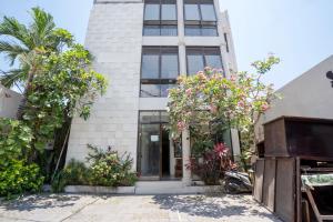 un bâtiment avec des plantes à fleurs devant lui dans l'établissement OYO 482 Anika Guest House, à Kuta