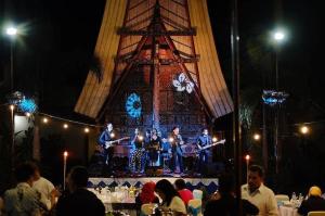 a band playing on a stage in front of a tower at Toraja Misiliana Hotel in Rantepao