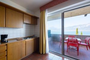 a kitchen with a table and chairs and a balcony at Residence Castelli in Brenzone sul Garda
