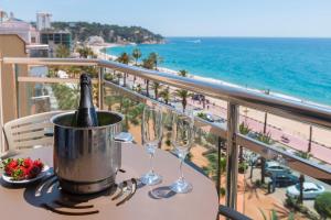 a table with a bottle of champagne and glasses on a balcony at Hotel Marsol in Lloret de Mar