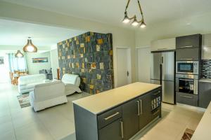 a kitchen and living room with a stove and refrigerator at New Villa Geranium in Grand Baie