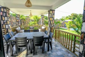 um deque com uma mesa e cadeiras de madeira em New Villa Geranium em Grand Baie