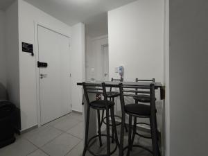 uma cozinha com um bar com bancos num quarto em Apartamento próximo ao shopping em Poços de Caldas