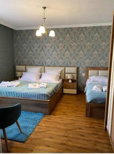 a bedroom with two beds and a chandelier at GOLDEN STAR KAZBEGI in Kazbegi