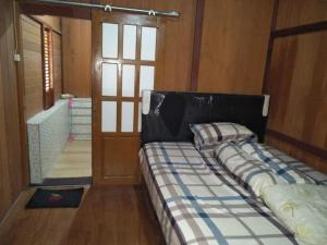 a bedroom with a bed in a room with a door at Comfortable Great and Cheap in Palu