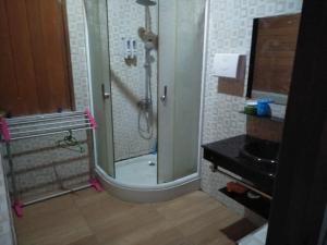 a bathroom with a shower with a glass door at Comfortable Great and Cheap in Palu