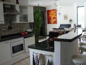 a kitchen with white cabinets and a black counter top at Villa Los Ojos in Charco del Palo