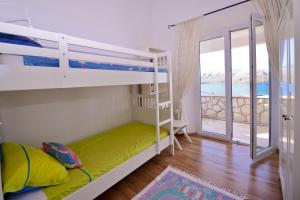 a bedroom with bunk beds with a view of the ocean at Holiday Home Fiola in Zubovići