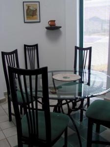 comedor con mesa de cristal y sillas en Villa Los Ojos, en Charco del Palo