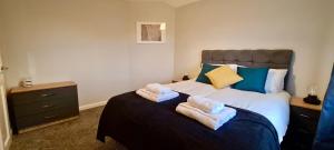 a bedroom with a bed with towels on it at ✪ Spacious Luxury 2-bed w/ parking & garden in Killingbeck