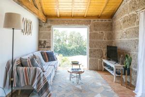- un salon avec un canapé et une télévision dans l'établissement Casa Monte do Cervo, à Vila Nova de Cerveira