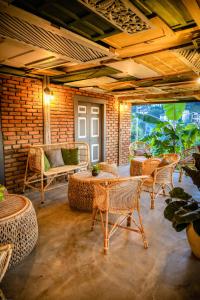 a patio with wicker chairs and tables in a room at Banana Bunks Kandy in Kandy