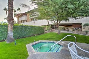 a swimming pool in a yard with a palm tree at Walk to Dtwn Palm Springs Condo with Pool Access in Palm Springs