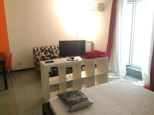 ナポリにあるMarechiaro Casaのベッド1台、テレビ、テーブルが備わる客室です。