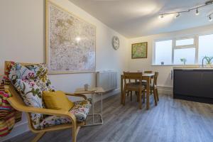 sala de estar con silla y mesa en Private deck with newly refurbished flat attached! en Cirencester