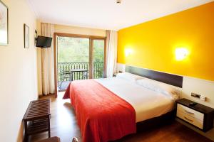 a hotel room with a bed and a balcony at Hotel Venta de Etxalar in Etxalar