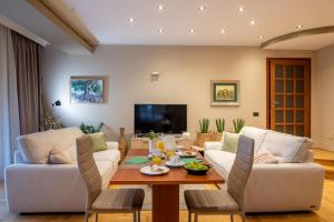 a living room with two white couches and a wooden table at Villa Milli B&B in Rovinj