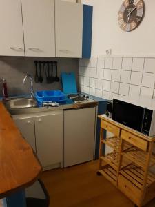eine kleine Küche mit einer Spüle und einer Mikrowelle in der Unterkunft studio jonquille in Le Tréport