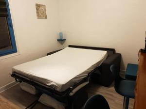 a hospital bed in a room with a chair at studio jonquille in Le Tréport